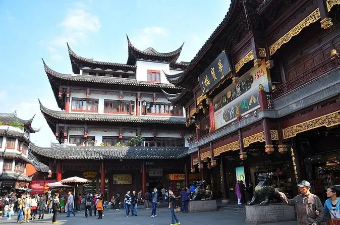 Une place de bazar bondée devant des bâtiments de style traditionnel dorés